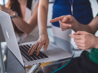 person pointing to laptop