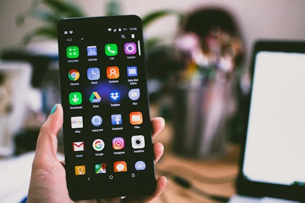Hand holding a mobile phone showing lots of Social Media apps