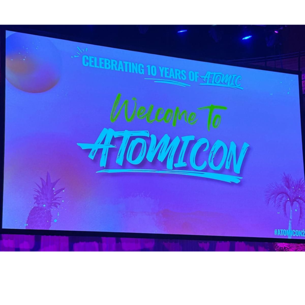Projector screen at ATOMICON 2024 event showing a welcome screen
